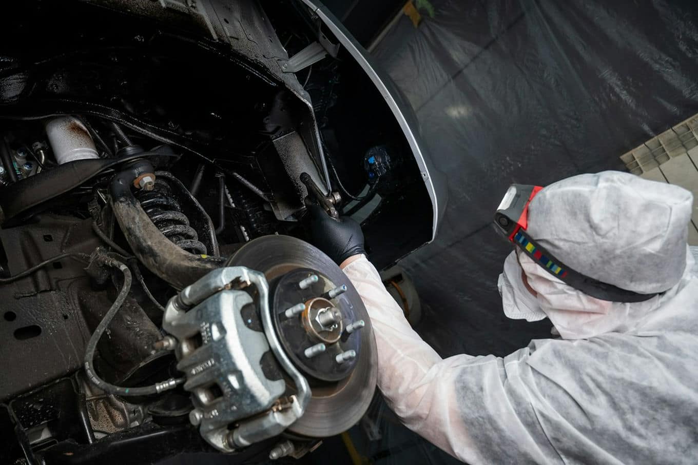mechanik nakłada powłokę antykorozyjną na podwozie samochodu.jpg